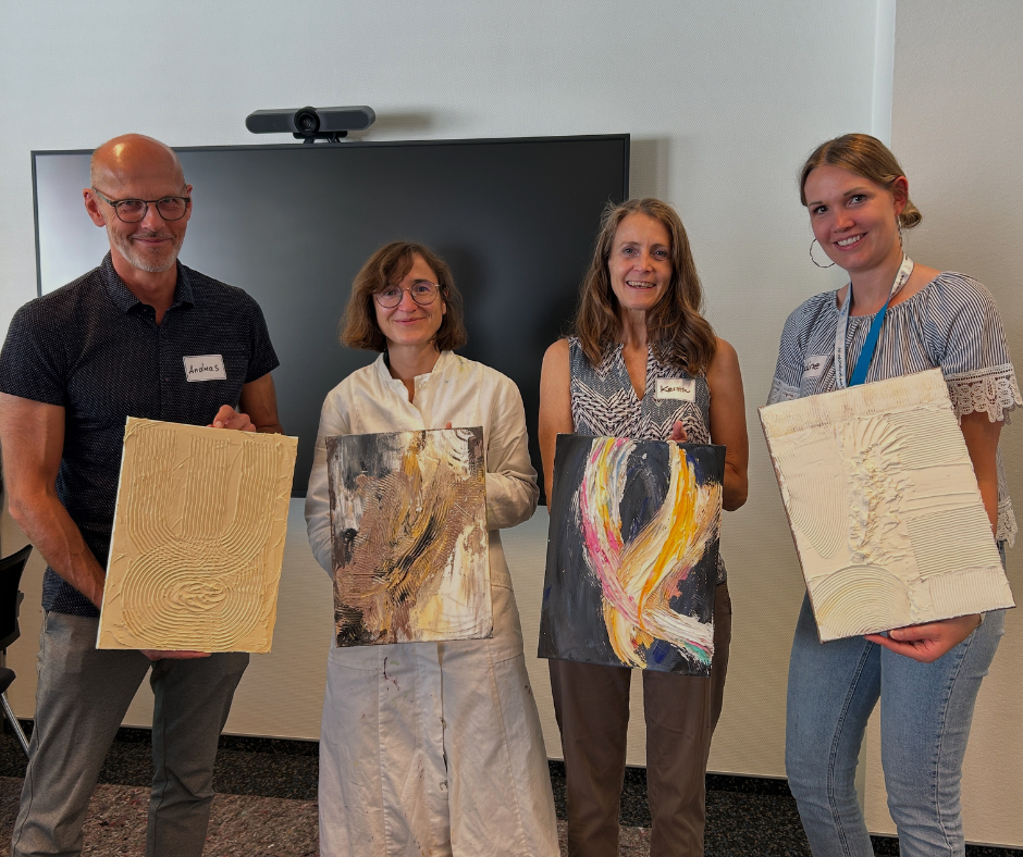 Gruppe, die ihr Kunstwerk zeigt