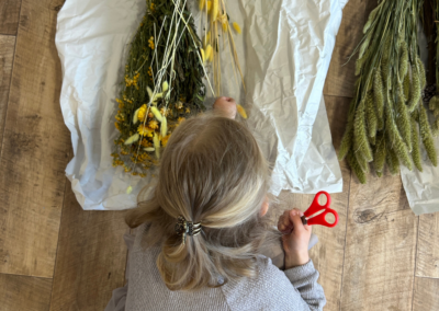 Ein Kind von oben, das gerade Trockenblumen aussucht